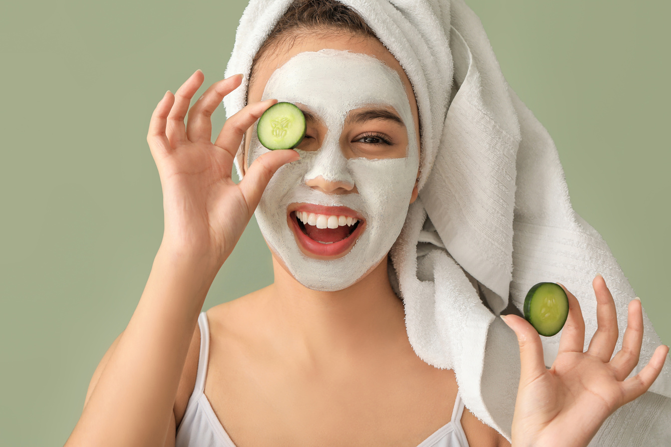 Young Woman with Cucumber Slices and Face Mask 